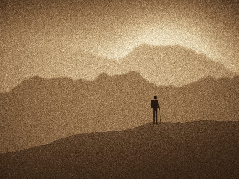 Randonneur au sommet d'une crête face à des montagnes dans la brume